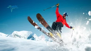 Skieur en plein saut sur les pistes, illustrant les bienfaits d'une préparation ski physiothérapie Medifit.